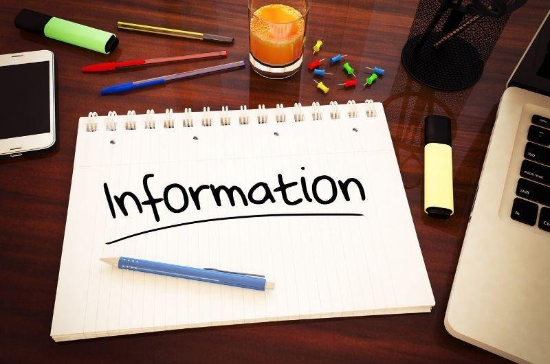 information written on paper next to laptop